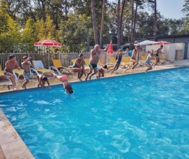 Bord de piscine avec enfants sautant au ZEcamping 3 étoiles parc aquatique vacances 100 % nature