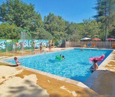 Piscine extérieure avec enfants et parasols au ZEcamping 3 étoiles parc aquatique