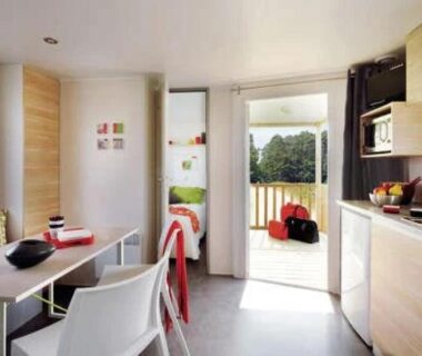 Intérieur du mobil-home avec coin cuisine et terrasse au ZEcamping 3 étoiles pet friendly avec piscine et pataugeoire