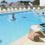 Piscine extérieure avec transats et baigneurs au ZEcamping 3 étoiles pet friendly piscine chauffée et piscine couverte
