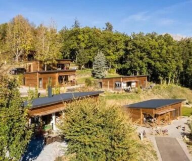 Vue aérienne de chalets en bois entourés d'arbres au ZEcamping 3 étoiles pet friendly restaurant avec une vue panoramique