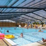 Piscine couverte avec bouées et enfants jouant au ZEcamping 3 étoiles