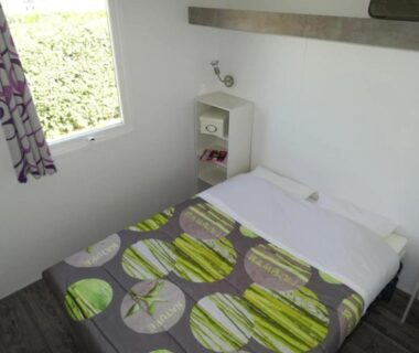 Chambre double avec lit et fenêtre au ZEcamping 3 étoiles piscine chauffée