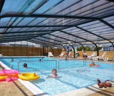 Piscine couverte avec bouées et enfants jouant au ZEcamping 3 étoiles