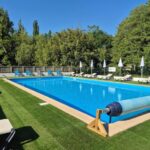 Piscine extérieure bordée de transats au ZEcamping 3 étoiles piscine chauffée dog friendly locatif BBQ clim