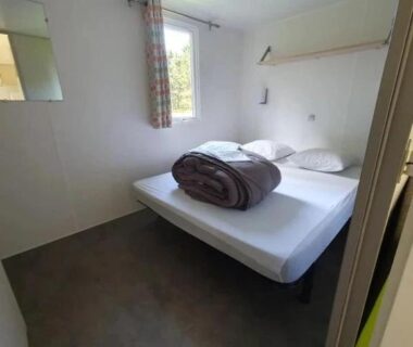 Chambre avec lit double et couverture dans le ZEcamping 3 étoiles piscine chauffée dog friendly locatif BBQ clim