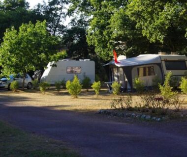 Emplacement de camping avec caravanes et arbres au ZEcamping 3 étoiles avec piscine chauffée et club enfant