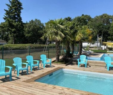 Bord de piscine en bois avec fauteuils colorés au ZEcamping 3 étoiles – piscine chauffée et club enfant