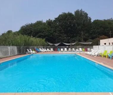 Piscine extérieure avec transats et clôture dans le camping ZEcamping 3 étoiles piscine chauffée et pataugeoire pet friendly
