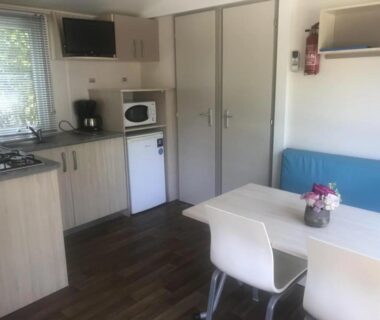 Intérieur mobil-home avec coin cuisine et banquette dans le ZEcamping 3 étoiles piscine chauffée et pataugeoire pet friendly
