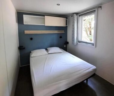 Chambre double avec lit et fenêtre au ZEcamping 3 étoiles piscine chauffée et pataugeoire pet friendly