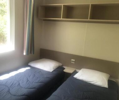Chambre avec deux lits simples et fenêtre au ZEcamping 3 étoiles piscine chauffée et pataugeoire pet friendly