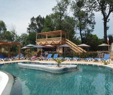 Piscine extérieure avec transats et terrasse au ZEcamping 3 étoiles