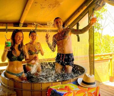 Terrasse avec bain en bois et personnes éclaboussant au ZEcamping 3 étoiles piscine chauffée soirées animées bar et restaurant
