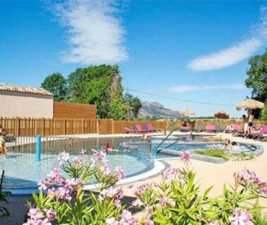 Piscine extérieure avec transats et fleurs au ZEcamping 3 étoiles piscine chauffée soirées animées bar et restaurant