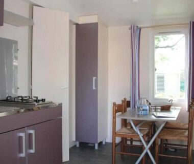 Intérieur mobil home avec kitchenette et table à manger au ZEcamping 3 étoiles piscine