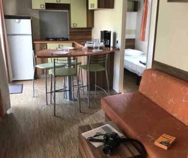 Intérieur de mobil-home avec kitchenette canapé et table au ZEcamping 3 étoiles piscine proche Provence et méditérrannée