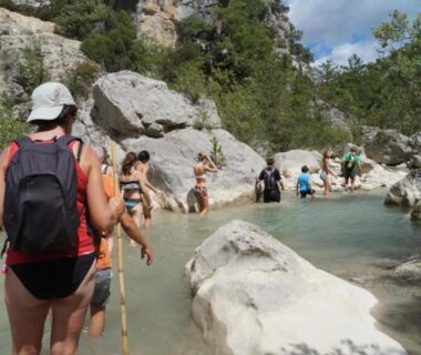 Rivière avec randonneurs traversant des rochers au ZEcamping 3 familial animaux acceptés bar piscine et soirées animées
