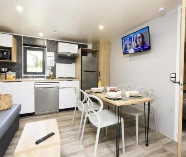 Intérieur du mobil-home avec kitchenette table et télévision du ZEcamping 4 étoiles Familial Parc Aqua Esprit Champêtre Dog Friendly
