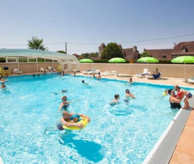 Piscine extérieure avec baigneurs et parasols au ZEcamping 4 étoiles Familial Parc Aqua