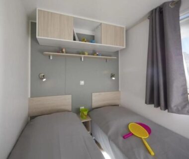 Chambre avec deux lits et raquette de plage dans le mobil-home ZEcamping 4 étoiles Parc Aqua