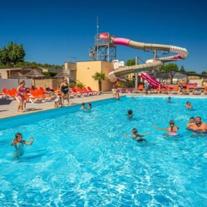 Piscine extérieure et toboggan avec baigneurs au camping ZEcamping 4 étoiles