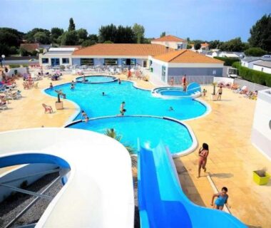 Piscine extérieure avec toboggan et transats au ZEcamping 4 étoiles