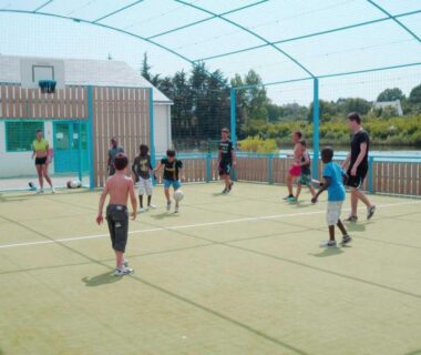 Terrain multisports couvert avec enfants jouant au ballon au ZEcamping 4 étoiles Carnac