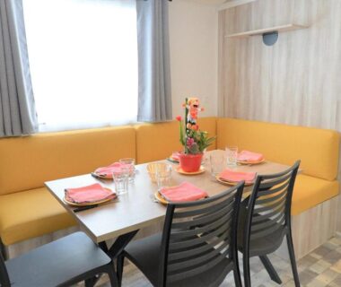 Coin repas avec banquette jaune dans le mobil-home du ZEcamping 4* Top Parc Aqua MH Climatisé
