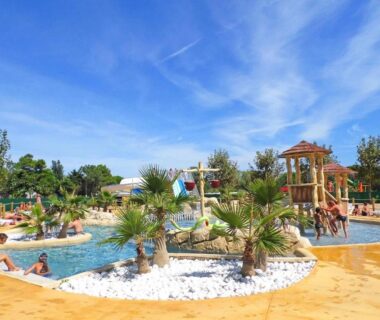 Piscine ludique avec toboggans et palmiers au ZEcamping 4 étoiles Top Parc Aqua