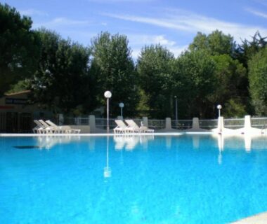Piscine extérieure avec chaises longues au ZEcamping 4 étoiles Top Parc Aqua Plage à 1 km MH Climatisé