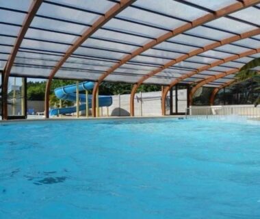 Piscine couverte avec toboggan et palmiers au ZEcamping 4 étoiles animaux acceptés et piscine couverte