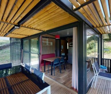 Terrasse couverte en bois avec baie vitrée et mobilier extérieur du ZEcamping 4 étoiles animaux acceptés tennis piscine couverte