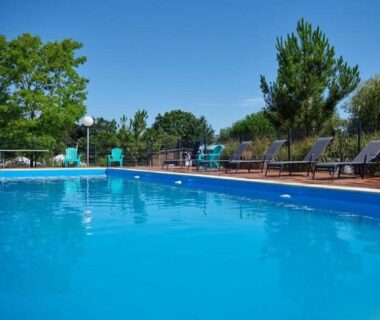Piscine extérieure bordée de transats au ZEcamping 4 étoiles animé
