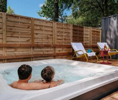 Terrasse avec jacuzzi et chaises longues au ZEcamping 4 étoiles animé avec piscine couverte
