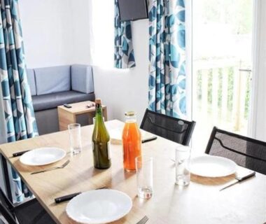Pièce à vivre avec table dressée et canapé dans ZEcamping 4 étoiles