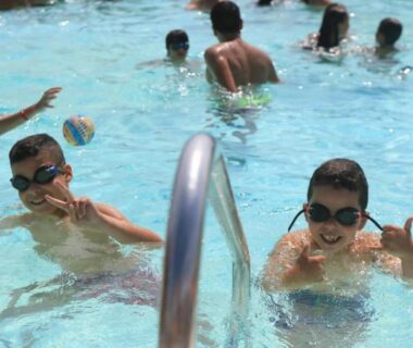 Piscine extérieure avec enfants jouant près de l'échelle au ZEcamping 4 étoiles