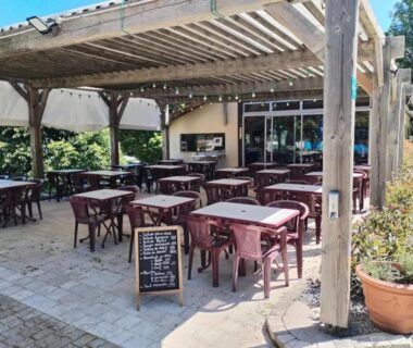 Terrasse couverte avec tables et chaises au ZEcamping 4 étoiles dog friendly