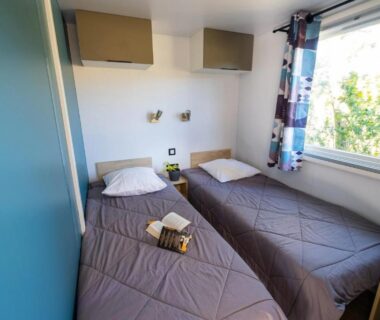Intérieur de mobil-home avec deux lits et climatisation dans le mobil-home ZEcamping 4 étoiles
