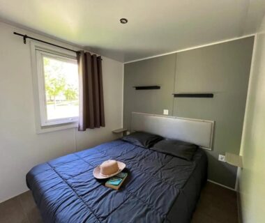 Chambre avec lit double et fenêtre dans le ZEcamping 4 étoiles familial animaux acceptés animé parc aquatique
