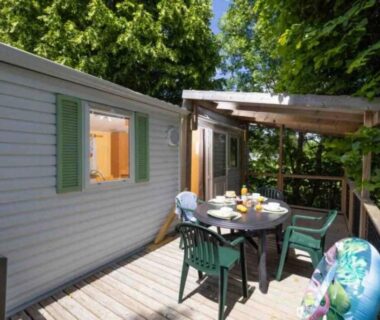 Terrasse en bois avec table et chaises au mobil-home du ZEcamping 4 étoiles familial parc aqua et soirées animées