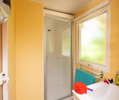 Salle de bain avec douche et lavabo dans l'hébergement ZEcamping 4 étoiles familial – parc aqua et soirées animées
