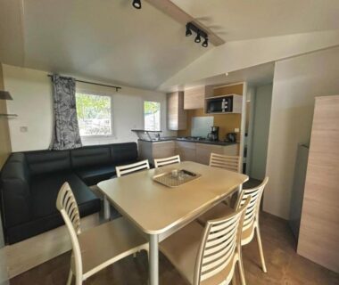 Intérieur locatif avec coin repas et salon au ZEcamping 4 étoiles familial