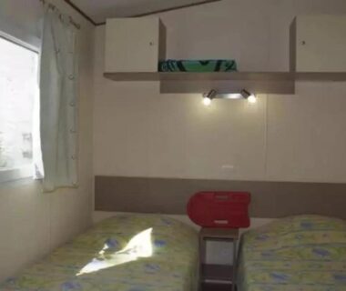 Mobil-home avec deux lits et fenêtre au ZEcamping 4 étoiles parc aquatique hammam et restaurant