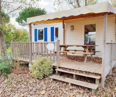 Terrasse en bois avec table et marches devant mobil-home climatisé du ZEcamping 4 étoiles piétonnier
