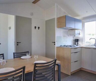 Séjour avec coin repas et kitchenette dans le mobil-home au ZEcamping 5 étoiles