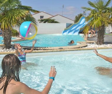 Piscine du camping avec toboggan et palmiers au ZEcamping 5 étoiles