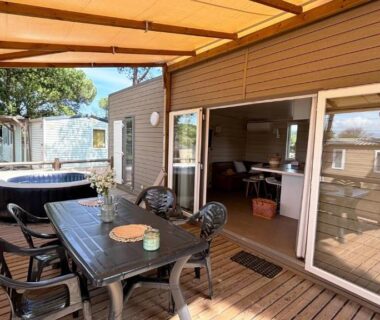 Terrasse en bois avec spa et table extérieure au ZEcamping 5 étoiles chiens acceptés animations parc aquatique