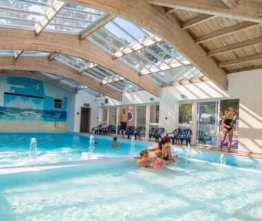 Piscine couverte avec bassin ludique et baigneurs au ZEcamping animations espace aquatique piscine couverte et restaurant