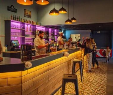 Bar intérieur avec comptoir et clients au ZEcamping animations espace aquatique piscine couverte et restaurant
